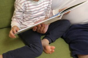 父親が子どもに絵本を読み聞かせている様子。